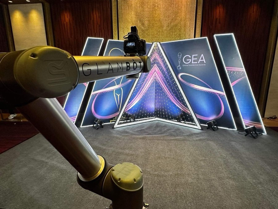 The GlamBot arm framing the Globe Excellence Awards backdrop before the show