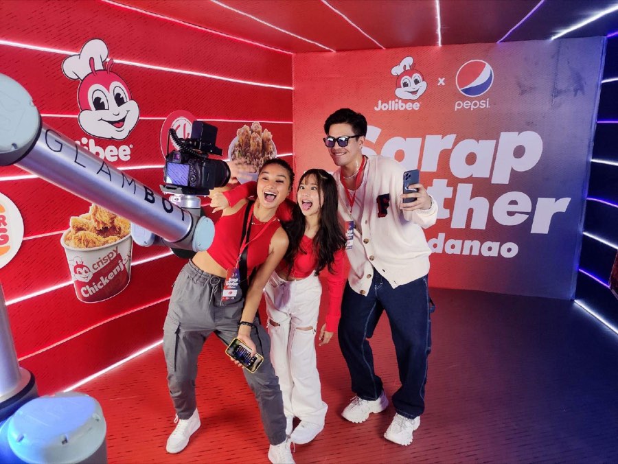 Guests posing with the branded GlamBot arm at the Jollibee x Pepsi Sarap Together activation